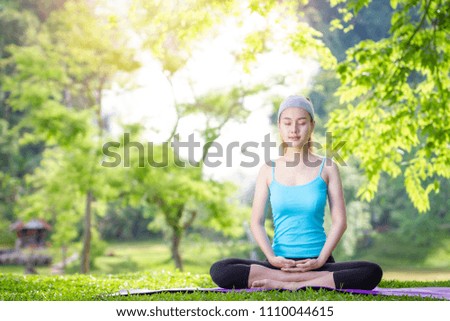Beautiful girl is playing yoga at the park. In the midst of nature Exercise concept