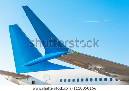 Winglets wings of the aircraft's tail and fuselage against the blue sky with the airplane on the flight level Royalty-Free Stock Photo #1110058166