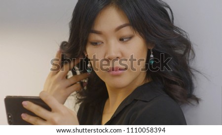 Young asian woman takes selfie in new designed earrings using smartphone