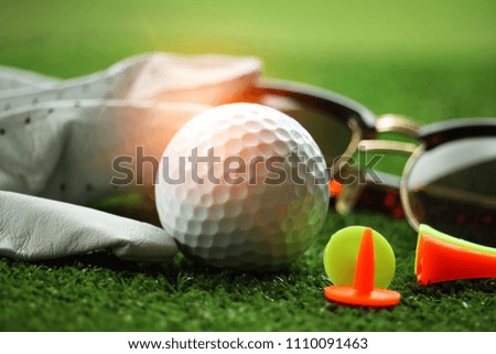 Golf equipment. Golf ball on the green grass in beautiful golf course at sunset background.