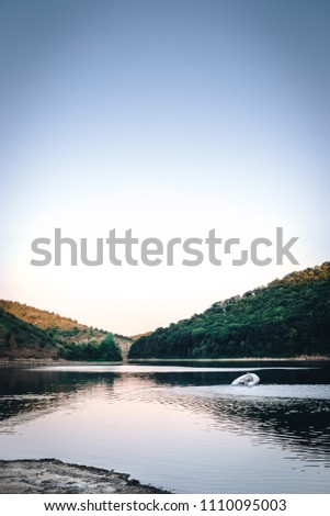the small white motor boat ride on the mountain river, sunset, fishing concept, vertical photo