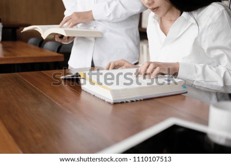 Closeup asian woman reading text book in library.
