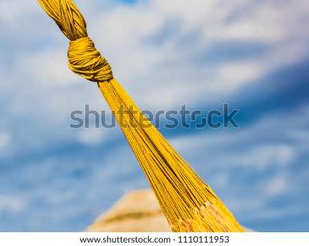 Yellow knot of hammock on the  blue sky background with text message space, diagonal composition