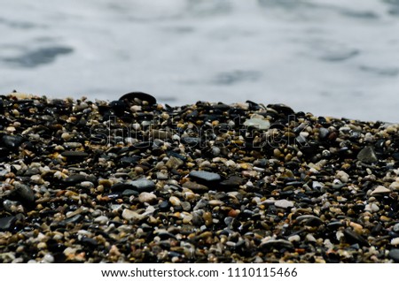 pebble beach washed by sea waves, small and various stones forming the shore, nature