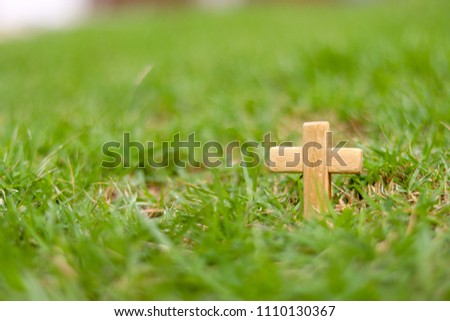 Wooden Christian cross on grass. Christianity Concept. Faith hope love concept.