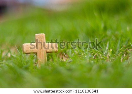 Wooden Christian cross on grass. Christianity Concept. Faith hope love concept.