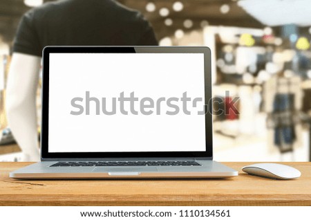Conceptual workspace, Laptop with blank screen on table with Supermarket blur background.