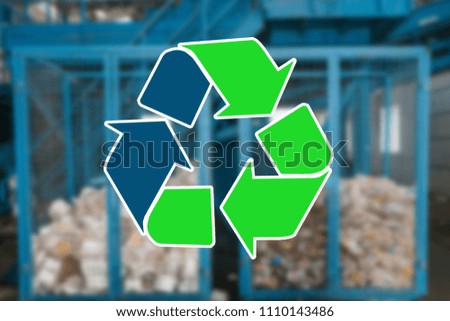 Sign recycling waste. The waste sorting and processing plant is blurry in the background
