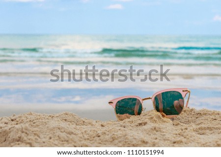 Eyeglasses put on sandy beach and blue sky in summer at Koh Kood, Trat, Thailand.