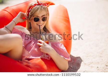 Woman drinking cocktail at the beach