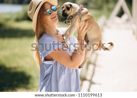 Woman in hat with cute dog at the beach