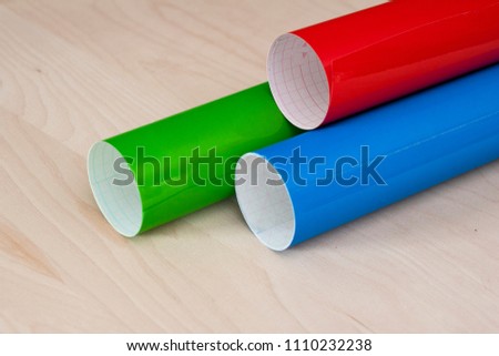 Colorful plotter foil which is used for industrial design on a wooden background photographed from above
