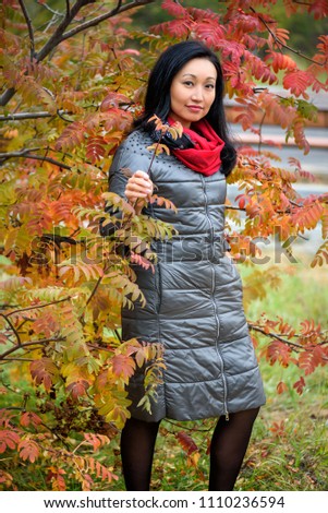 Fall woman smiling - Autumn portrait of happy lovely and beautiful mixed race Asian Caucasian young woman in forest in fall colors.