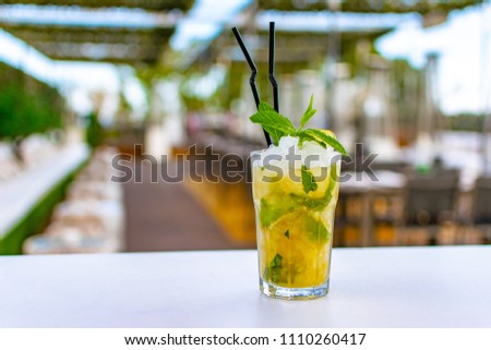 a chilled lime green mojito cocktail on a rooftop bar