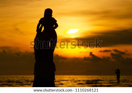 Silhouette Mom and the baby be happy behind the sea and sunset, koh chang trat thailand 23 May 2016.