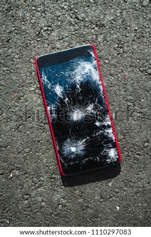 Smartphone with broken screen on the ground