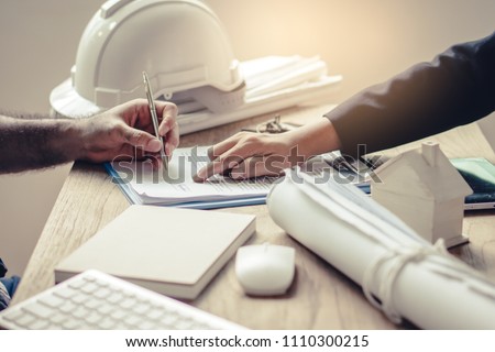 Business partners contract agreement success. Top view of close up hand of bank broker showing to client where to sign signature in contract for housing loan. Document in picture is fake.