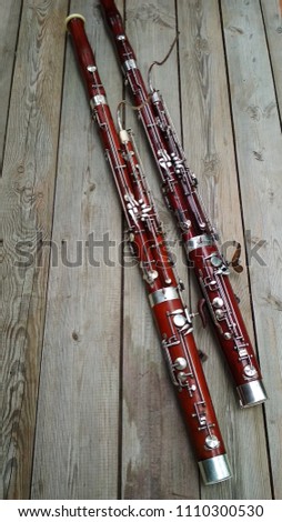 Two musical instruments, a bassoon on a wooden old surface. Royalty-Free Stock Photo #1110300530