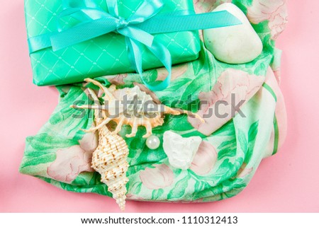fletley background image. On a beautiful silk scarf are seashells with pearls and a gift. View from above.