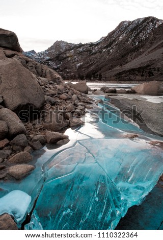 Beautiful blue ice reflects the last light on a California Alpine lake