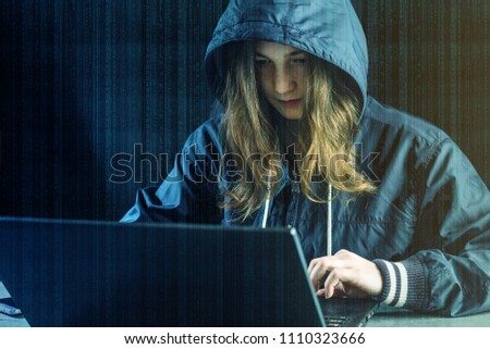 Girl hacker uses a laptop to hack the system. Stealing personal data. Creation and infection of malicious virus. The concept of cyber crime and hacking electronic devices