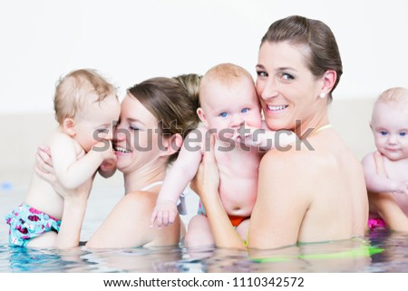 Mothers and their little babies having fun at infant swimming class