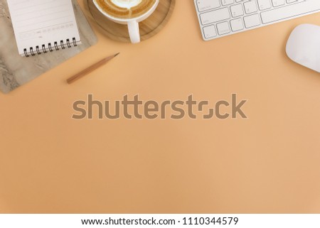 Flat lay, top view office table desk. Workspace with blank note book, keyboard, office supplies and coffee cup on light brown background.