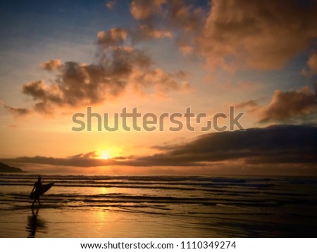 A man going to surf in the morning when the sun is rising