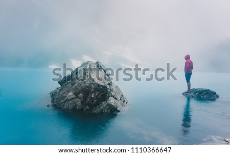 Beautiful view of peak called "Finger of God" with sorapis lake in foreground. dolomiti, italy. Dramatic sky with young woman bathing in the sorapis lake