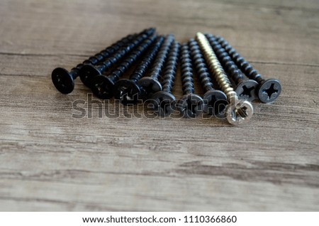 Screws for construction on a wooden background, metal screw, iron screw.