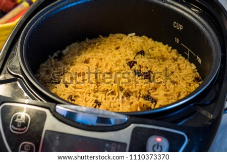 Close-up image of Pilaf with beef, carrots, onions, garlic, pepper and cumin in the modern multicooker. A traditional dish of Asian cuisine. Selective focus.