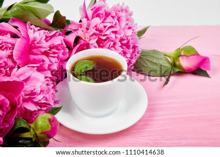 Bouquet Peony flowers on pink backgroun and  cup of coffee. Copy space. Good morning.