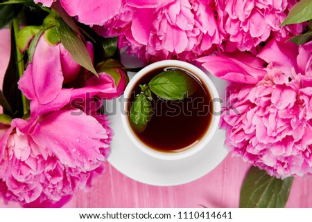 Bouquet Peony flowers on pink backgroun and  cup of coffee. Copy space.  flat lay. Good morning.