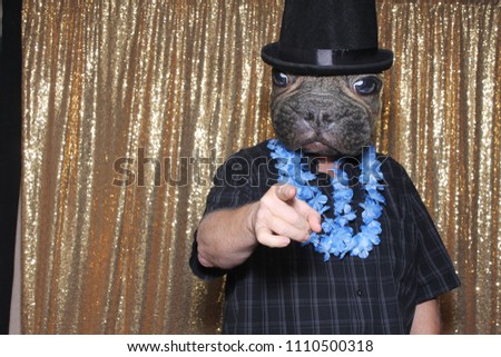 A happy middle aged man in a Photo Booth.  A man wears a Dog Mask and Top Hat while posing in a Photo Booth at a party. Party Time Photo Booth. 