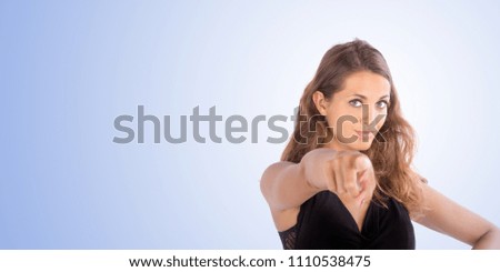 Pretty girl pointing with her hand up. Copy space photo with customizable background.