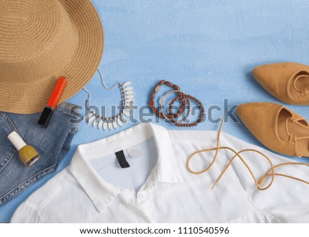 Summer outfit concept, woman clothes, accessories and make up on light blue background top view, copy space