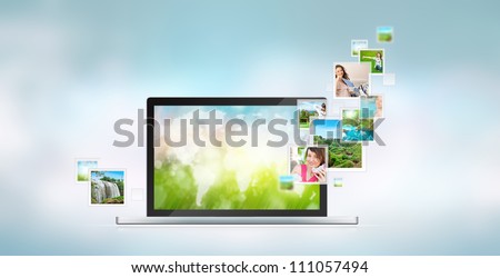 Open laptop at blue background. Pictures are flying out of the screen