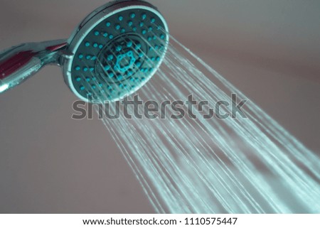 Closeup of a shower head with spraying water, toned photo.