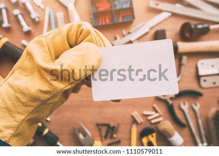 Repairman blank business card as copy space over workshop table with maintenance and fix-up project tools