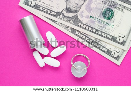 Metal container for pills and money on a pink background, concept of expensive drugs, close-up