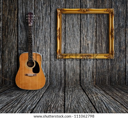 Guitar and picture frame in vintage wood room.