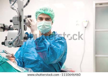 Eye surgeon at work. Young caucacian male surgeon performing surgery on a senior patient. Real operating theater room. Medical concept. Royalty-Free Stock Photo #1110646460