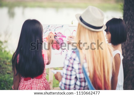 Mother and daughter drawing picture together in the park