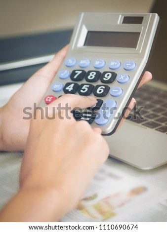 Woman accountant or bank worker uses calculator in the office to business profit and loss account.