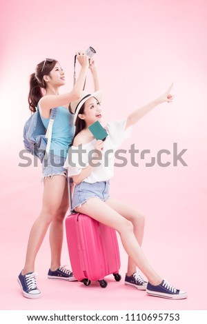 two beauty woman take camera and passport smile happily on the pink background