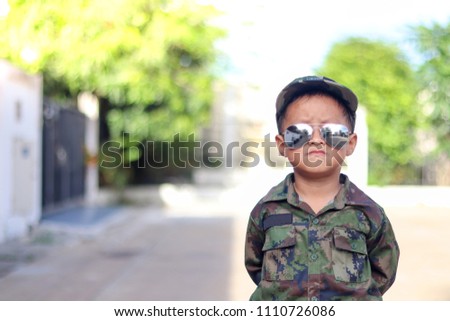 Little boy wearing soldier suit.