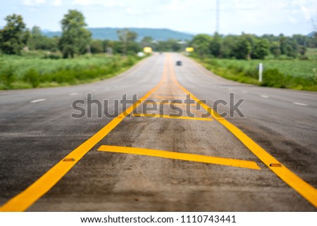 Long road or highway on sky blue or azure sky and cloud.  It on blurred background of mountanin 