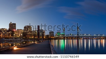 City skyline at night with pier leading to waterfront skyscrapers and bridge. Taken in Portland, Oregon
