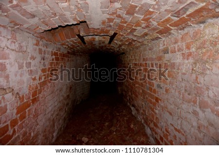 Dungeon. Underground passage, tunnel, arch laid out red brick. Secret ancient passage under the ground.