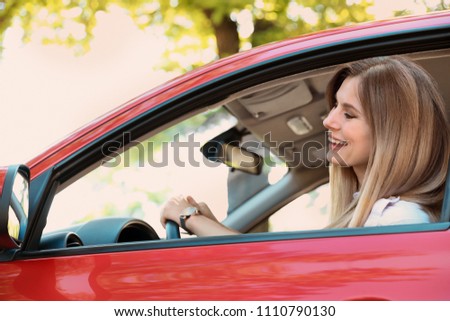 Happy beautiful woman driving modern car
